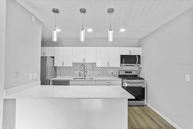1700 SW 16th Ct Unit J21, Gainesville, FL 32608 - kitchen with stainless steel appliances, a sink, a peninsula, light countertops, and light wood finished floors