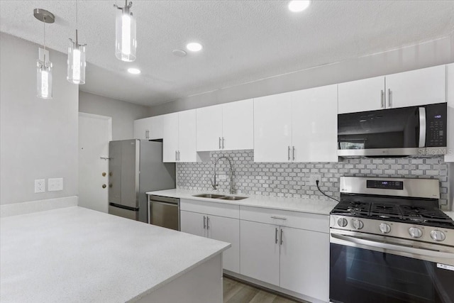 1700 SW 16th Ct Unit J21, Gainesville, FL 32608 - kitchen with appliances with stainless steel finishes, a sink, light countertops, white cabinetry, and decorative backsplash