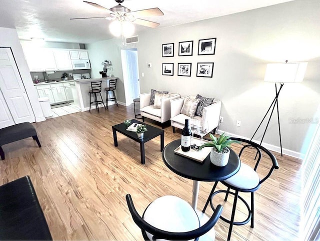 1700 SW 16th Ct Unit D30, Gainesville, FL 32608 - living room featuring light wood-style floors, ceiling fan, and baseboards