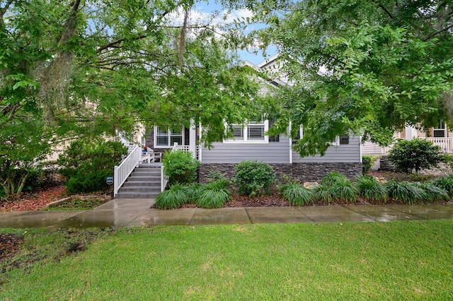 2638 SW 118th Ter, Gainesville, FL 32608 - view of property hidden behind natural elements with a front lawn, a porch, and stone siding