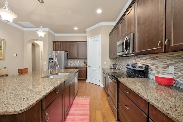 2638 SW 118th Ter, Gainesville, FL 32608 - kitchen with stainless steel appliances, a sink, light wood-type flooring, light stone countertops, and tasteful backsplash