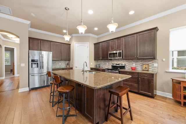 2638 SW 118th Ter, Gainesville, FL 32608 - kitchen featuring stainless steel appliances, a sink, a kitchen bar, dark brown cabinetry, and light stone counters