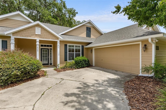 8360 SW 74th Pl, Gainesville, FL 32608 - view of front of home with roof with shingles, a garage, concrete driveway, and covered porch
