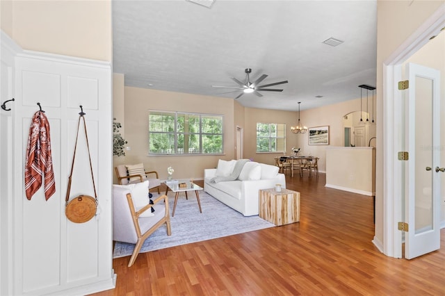 8360 SW 74th Pl, Gainesville, FL 32608 - living room with light wood finished floors, ceiling fan, baseboards, and a chandelier