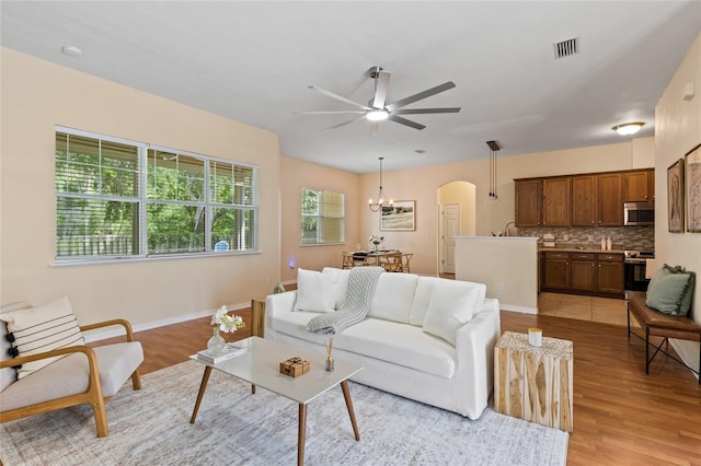 8360 SW 74th Pl, Gainesville, FL 32608 - living area featuring a ceiling fan, arched walkways, light wood finished floors, and a chandelier