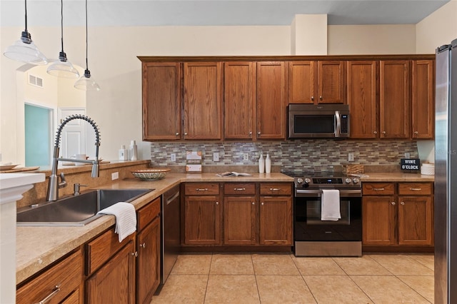 8360 SW 74th Pl, Gainesville, FL 32608 - kitchen with appliances with stainless steel finishes, a sink, tasteful backsplash, light tile patterned flooring, and pendant lighting