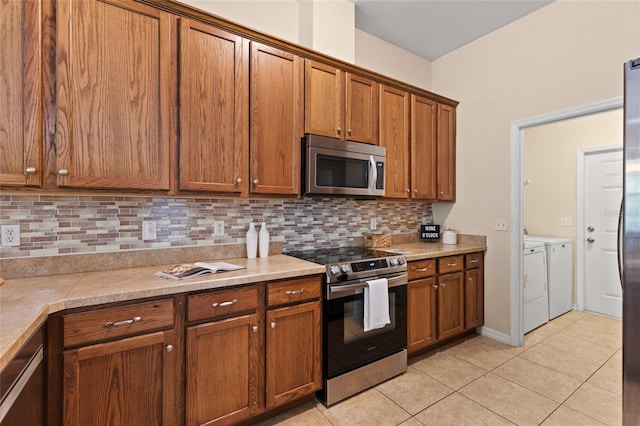 8360 SW 74th Pl, Gainesville, FL 32608 - kitchen with appliances with stainless steel finishes, independent washer and dryer, brown cabinets, and tasteful backsplash