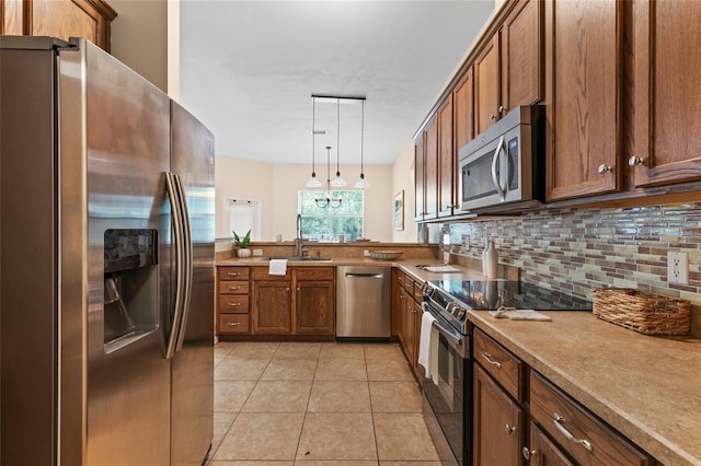 8360 SW 74th Pl, Gainesville, FL 32608 - kitchen with appliances with stainless steel finishes, a sink, tasteful backsplash, brown cabinets, and decorative light fixtures