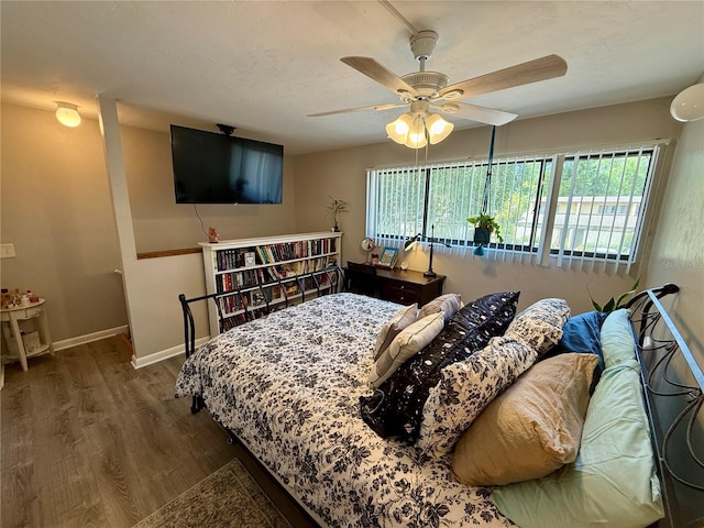 2058 SW 35th Pl Unit H47, Gainesville, FL 32608 - bedroom with wood finished floors, multiple windows, ceiling fan, and baseboards