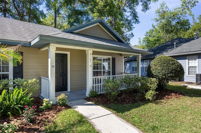 8103 SW 71st Ln, Gainesville, FL 32608 - view of front of house featuring covered porch, roof with shingles, and a front lawn
