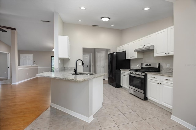 8103 SW 71st Ln, Gainesville, FL 32608 - kitchen with stainless steel range with gas stovetop, a sink, under cabinet range hood, freestanding refrigerator, and white cabinets