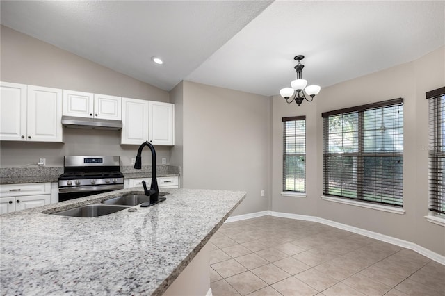 8103 SW 71st Ln, Gainesville, FL 32608 - kitchen with gas stove, under cabinet range hood, light tile patterned floors, a chandelier, and white cabinets