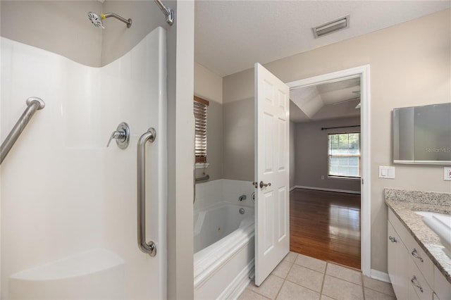 8103 SW 71st Ln, Gainesville, FL 32608 - full bathroom featuring tile patterned floors, a jetted tub, vanity, a shower, and baseboards