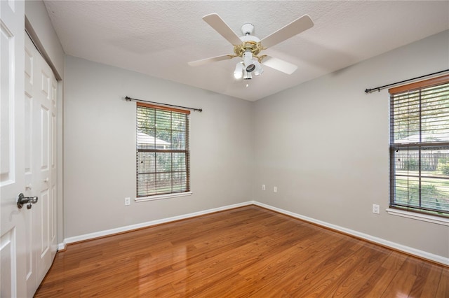 8103 SW 71st Ln, Gainesville, FL 32608 - unfurnished bedroom featuring light wood-style floors, a closet, baseboards, ceiling fan, and a textured ceiling