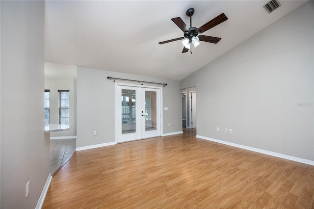 8103 SW 71st Ln, Gainesville, FL 32608 - spare room featuring french doors, a ceiling fan, light wood-type flooring, baseboards, and high vaulted ceiling