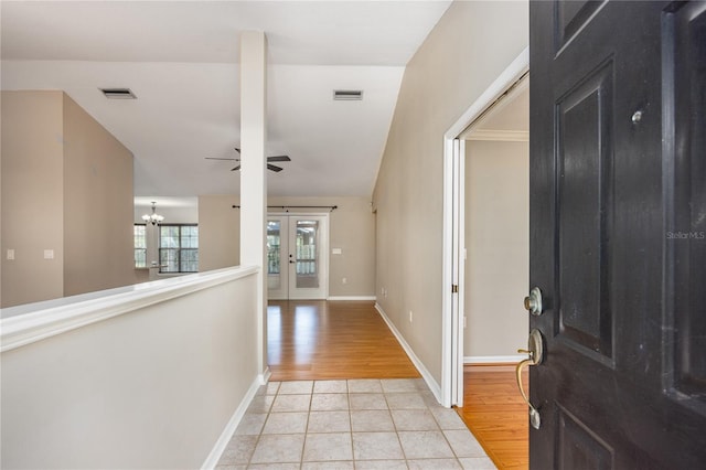 8103 SW 71st Ln, Gainesville, FL 32608 - foyer featuring light tile patterned floors, french doors, a ceiling fan, a chandelier, and baseboards