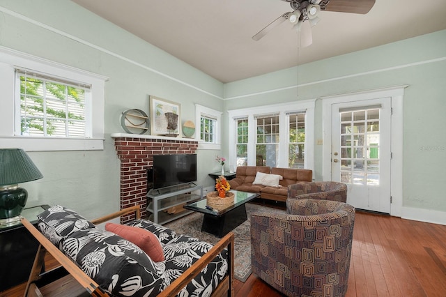 119 NW 7th Ter, Gainesville, FL 32601 - living area featuring a ceiling fan, wood-type flooring, baseboards, and a brick fireplace
