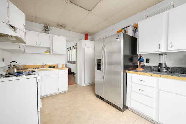 119 NW 7th Ter, Gainesville, FL 32601 - kitchen with stainless steel refrigerator with ice dispenser, white gas stove, a paneled ceiling, white cabinets, and open shelves