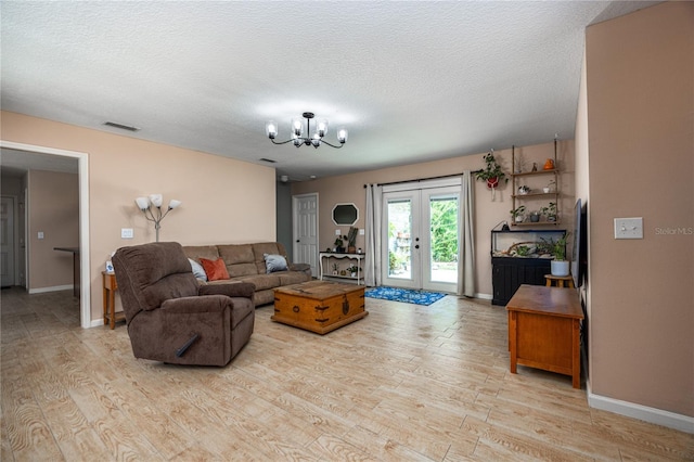 1841 SE 245th St, Hawthorne, FL 32640 - living room with light wood finished floors, a chandelier, french doors, baseboards, and a textured ceiling