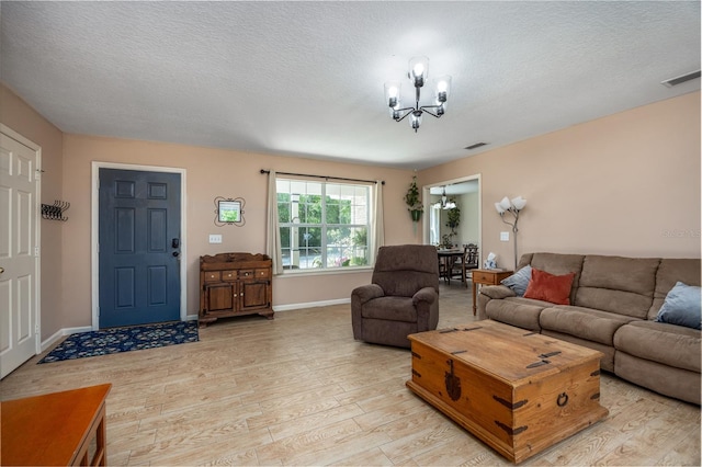 1841 SE 245th St, Hawthorne, FL 32640 - living room with a chandelier, light wood-type flooring, a textured ceiling, and baseboards