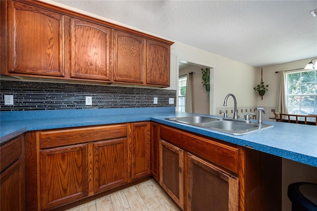 1841 SE 245th St, Hawthorne, FL 32640 - kitchen with a sink, backsplash, brown cabinetry, and a textured ceiling