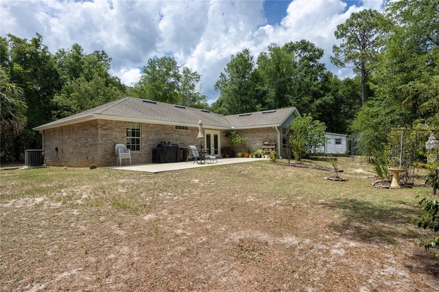 1841 SE 245th St, Hawthorne, FL 32640 - back of house featuring a patio area, french doors, brick siding, cooling unit, and a lawn