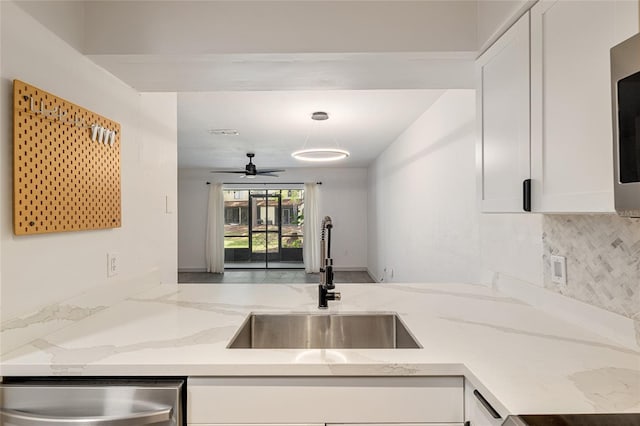 2735 SW 35th Pl Unit 1905, Gainesville, FL 32608 - kitchen featuring stainless steel dishwasher, white cabinetry, tasteful backsplash, and light stone counters