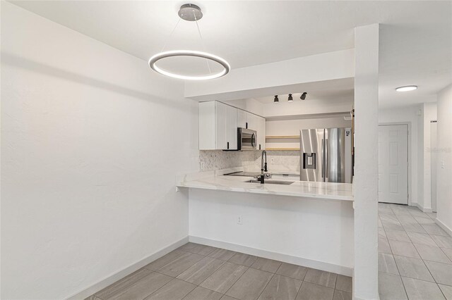 2735 SW 35th Pl Unit 1905, Gainesville, FL 32608 - kitchen featuring stainless steel appliances, tasteful backsplash, light countertops, a peninsula, and white cabinets