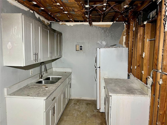 1700 SW 16th Ct Unit D25, Gainesville, FL 32608 - kitchen with a sink, freestanding refrigerator, light countertops, baseboards, and white cabinets