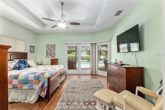 13615 SW 1st Ln, Newberry, FL 32669 - bedroom featuring a tray ceiling, french doors, access to outside, wood finished floors, and a ceiling fan