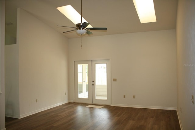 7518 NW 35th Pl, Gainesville, FL 32606 - spare room with a skylight, dark wood finished floors, lofted ceiling, a ceiling fan, and baseboards