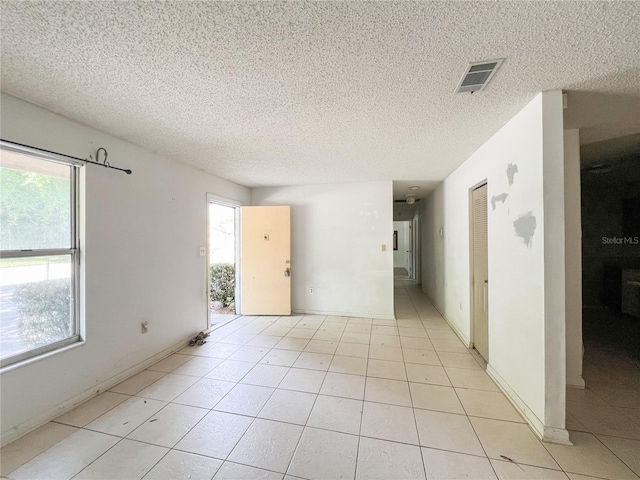 6226 SW 10th Pl, Gainesville, FL 32607 - spare room with a textured ceiling, light tile patterned floors, and baseboards