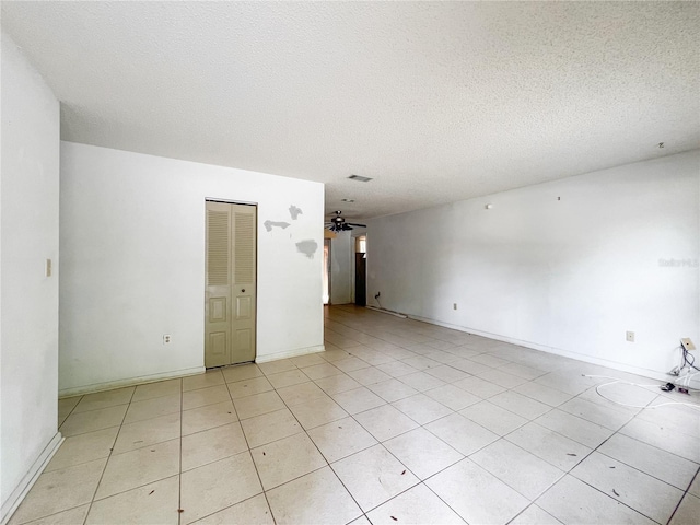 6226 SW 10th Pl, Gainesville, FL 32607 - empty room featuring a textured ceiling, light tile patterned floors, and baseboards