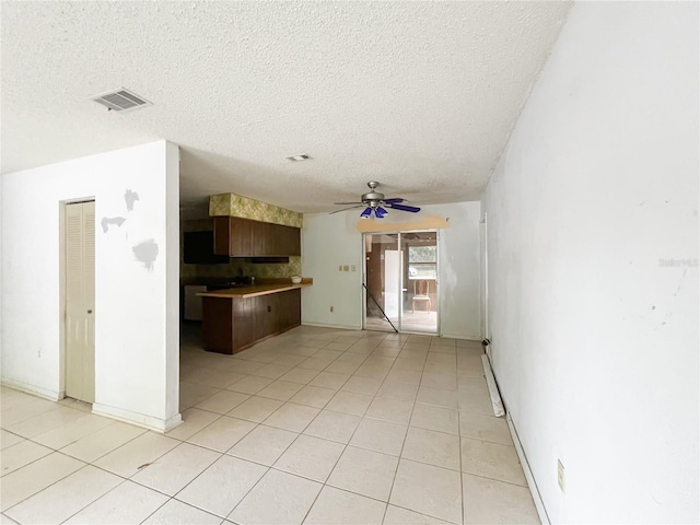 6226 SW 10th Pl, Gainesville, FL 32607 - kitchen featuring a textured ceiling, a ceiling fan, light tile patterned floors, and tasteful backsplash