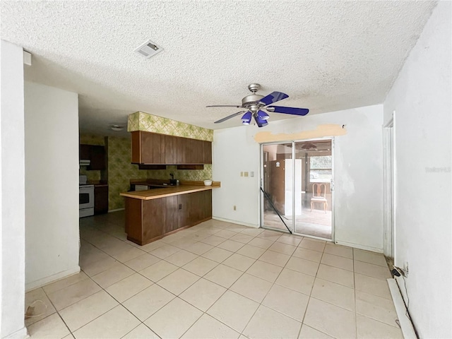 6226 SW 10th Pl, Gainesville, FL 32607 - kitchen featuring stainless steel range with electric stovetop, a peninsula, a ceiling fan, a textured ceiling, and light tile patterned floors