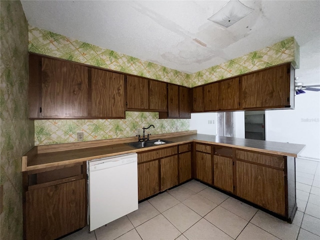 6226 SW 10th Pl, Gainesville, FL 32607 - kitchen featuring white dishwasher, a sink, wallpapered walls, light tile patterned floors, and a peninsula