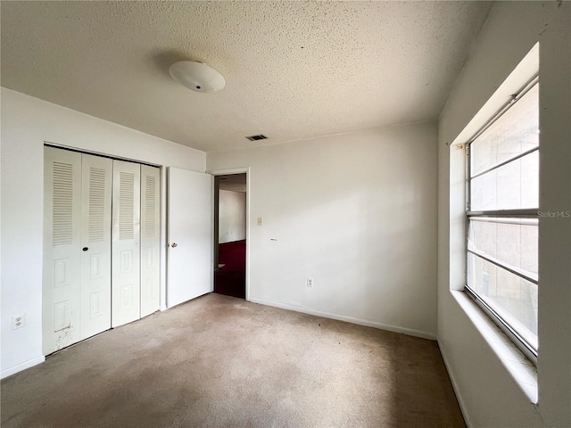 6226 SW 10th Pl, Gainesville, FL 32607 - unfurnished bedroom featuring a textured ceiling, a closet, carpet floors, and baseboards