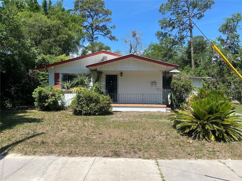 1212 NE 5th Ter, Gainesville, FL 32601 - view of front of house featuring a porch and a front yard
