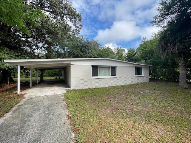 3008 NE 11th Dr, Gainesville, FL 32609 - view of front of home with asphalt driveway, concrete block siding, an attached carport, and a front lawn