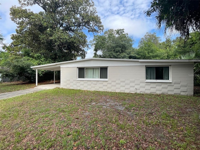 3008 NE 11th Dr, Gainesville, FL 32609 - view of home's exterior featuring concrete driveway, a carport, and a yard