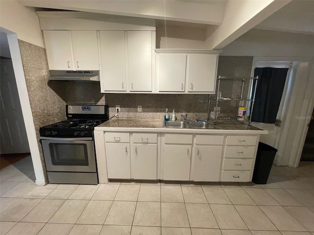 3008 NE 11th Dr, Gainesville, FL 32609 - kitchen featuring gas stove, a sink, under cabinet range hood, light tile patterned floors, and white cabinets