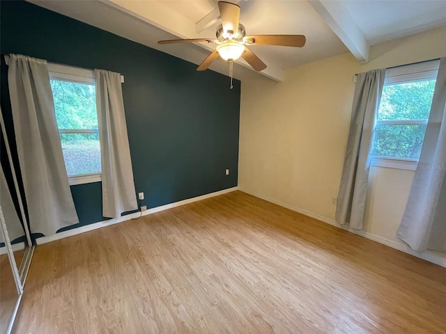 3008 NE 11th Dr, Gainesville, FL 32609 - spare room with healthy amount of natural light, wood finished floors, beam ceiling, ceiling fan, and baseboards