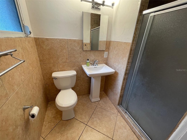 3008 NE 11th Dr, Gainesville, FL 32609 - full bathroom featuring toilet, a stall shower, tile walls, a wainscoted wall, and tile patterned flooring