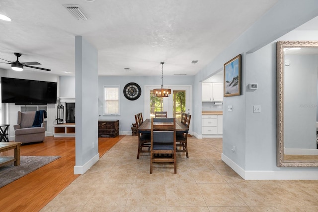 1412 SW 98th St, Gainesville, FL 32607 - dining space featuring a chandelier, a ceiling fan, baseboards, and light wood finished floors