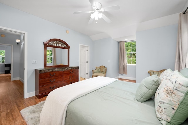 1412 SW 98th St, Gainesville, FL 32607 - bedroom featuring baseboards, multiple windows, wood finished floors, vaulted ceiling, and a ceiling fan