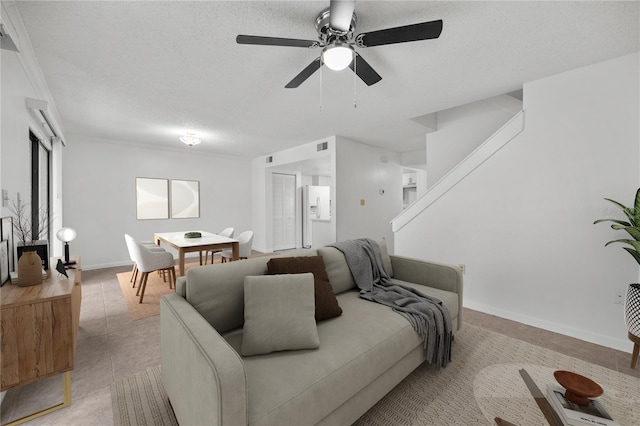3026 NW 28th Cir, Gainesville, FL 32605 - living room featuring ceiling fan, light tile patterned flooring, a textured ceiling, and baseboards