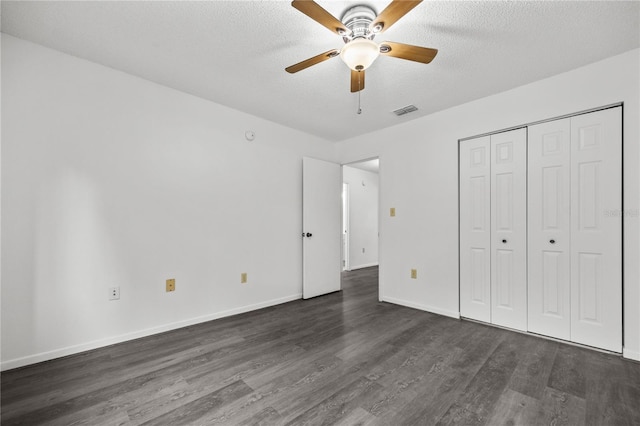 3026 NW 28th Cir, Gainesville, FL 32605 - unfurnished bedroom featuring dark wood-style floors, a textured ceiling, baseboards, ceiling fan, and a closet