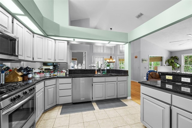 5434 SW 91st Ter, Gainesville, FL 32608 - kitchen featuring appliances with stainless steel finishes, a sink, a chandelier, light tile patterned floors, and gray cabinets