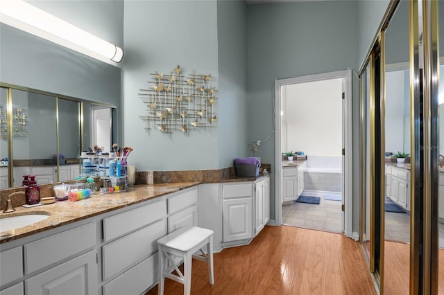 5434 SW 91st Ter, Gainesville, FL 32608 - full bathroom featuring wood finished floors, vanity, and a garden tub