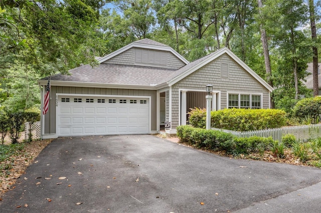 5434 SW 91st Ter, Gainesville, FL 32608 - view of front of property featuring asphalt driveway, a shingled roof, an attached garage, and view of scattered trees